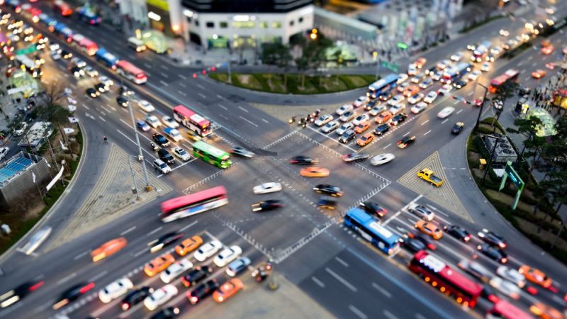Das Foto zeigt eine belebte Verkehrskreuzung in einer Stadt.